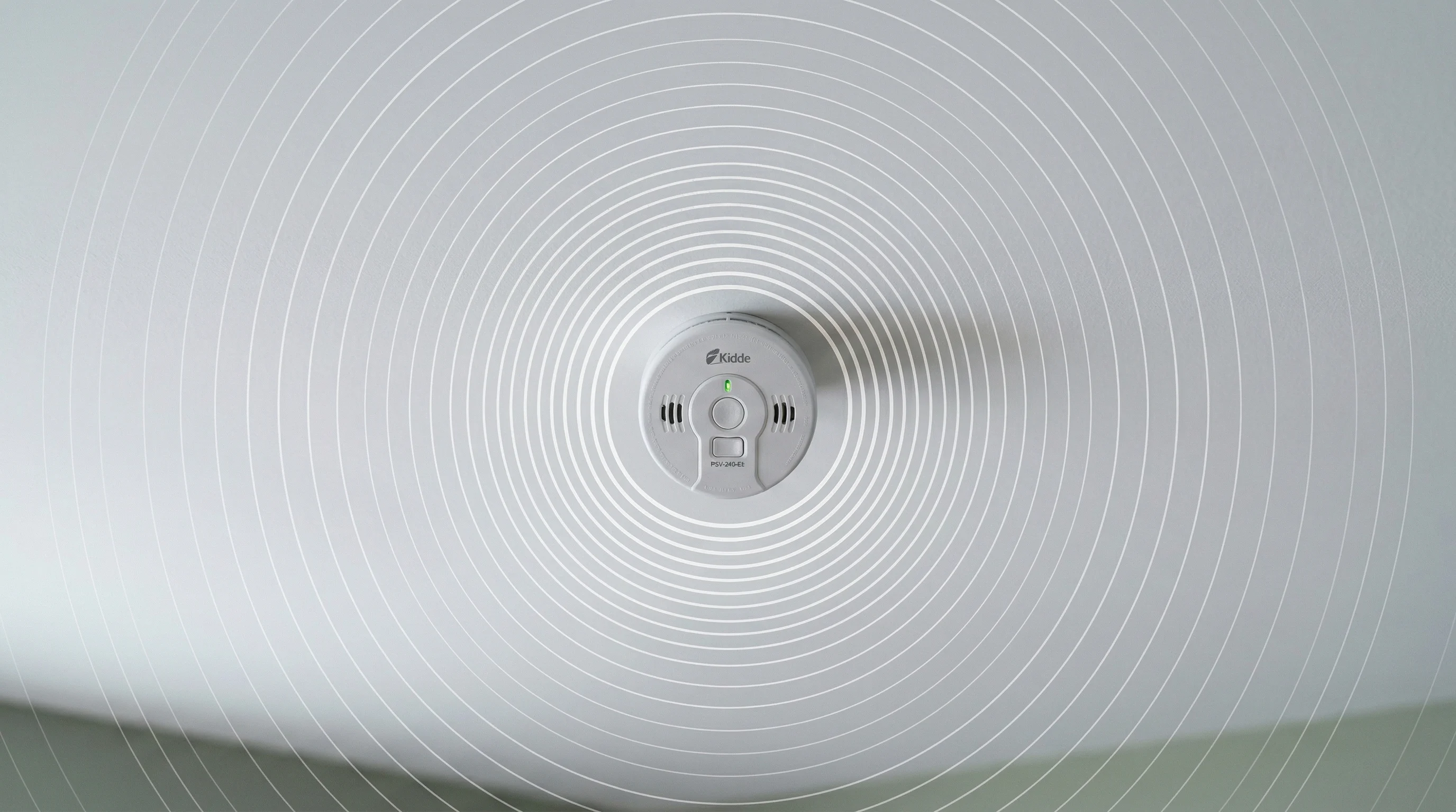 Smoke alarm on ceiling with concentric sound wave rings